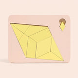 Yellow geometric pieces form a diamond inside a pale pink puzzle board with a small diamond tab against a peach background.