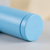 Close-up of the light blue water gun’s rounded cylindrical end resting on a gray surface against a blurred beige background.
