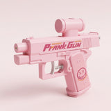 Pink water gun with a cylindrical top attachment and a crossed-eye face graphic on the grip, shown against a pale pink background.
