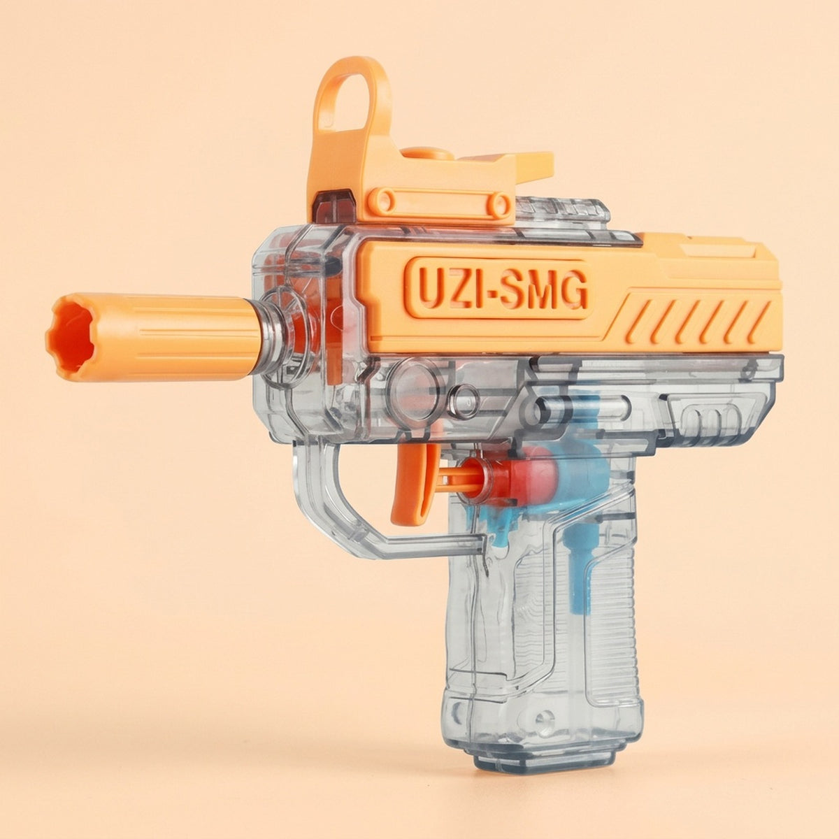 An orange and transparent water gun faces left against a peach background, with an orange trigger and clear grip.