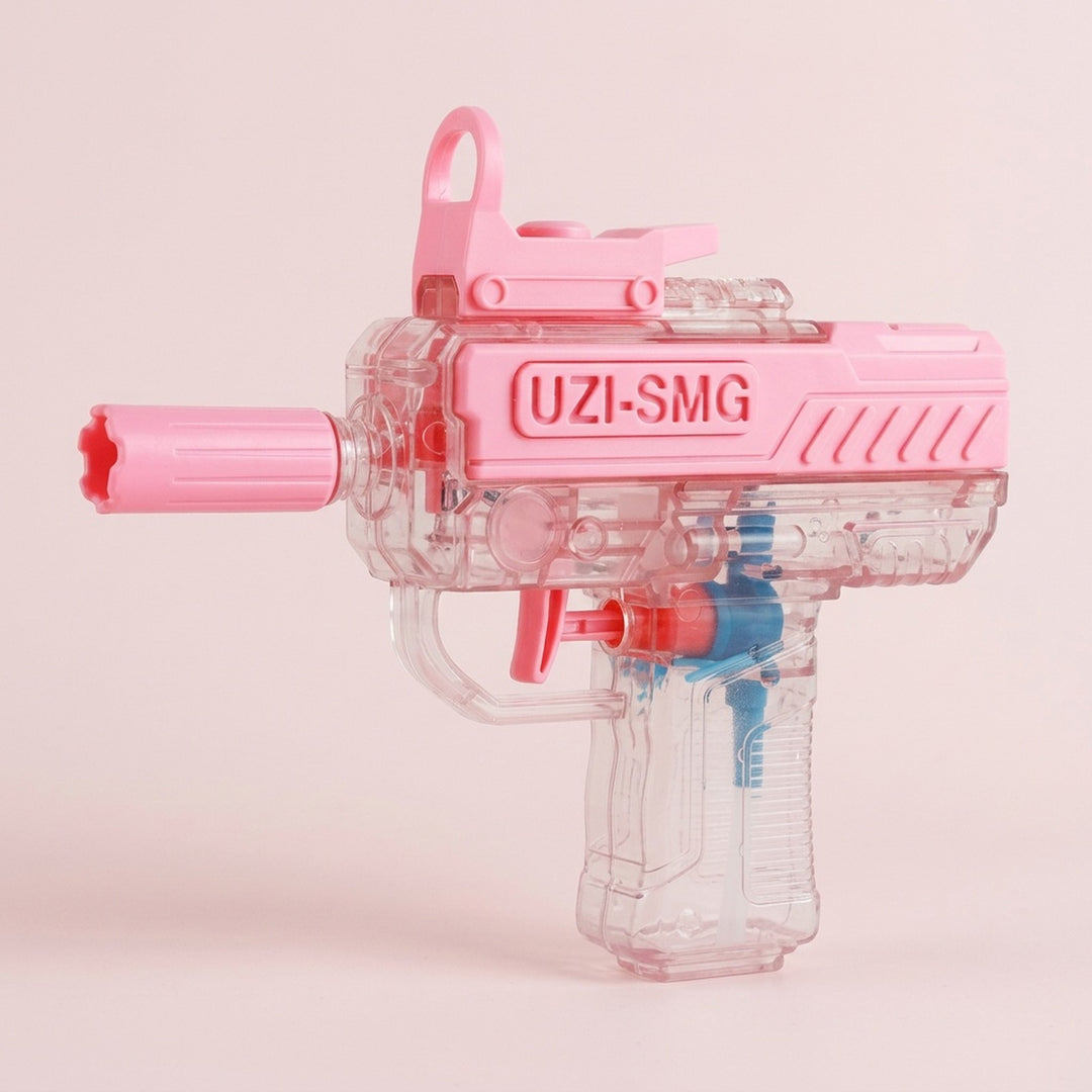A pink and transparent water gun faces left against a pale pink background, showing blue and red internal components.
