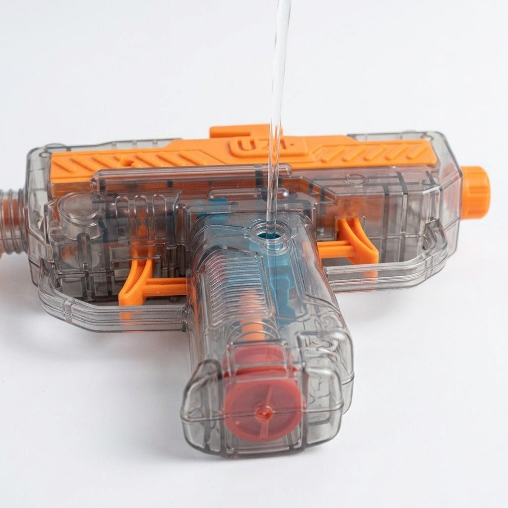 An orange and transparent water gun lies on a white surface while water pours into an opening in its grip.