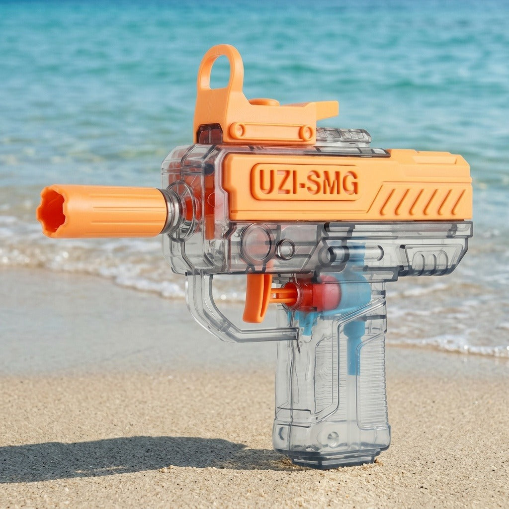 An orange and transparent water gun stands on sand beside turquoise seawater and small breaking waves.