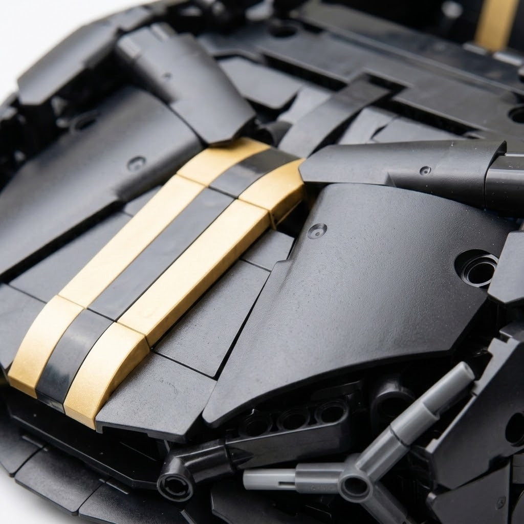 Close-up of the assembled car building kit showing black molded plastic hood panels, twin gold stripes, and gray connecting pieces.