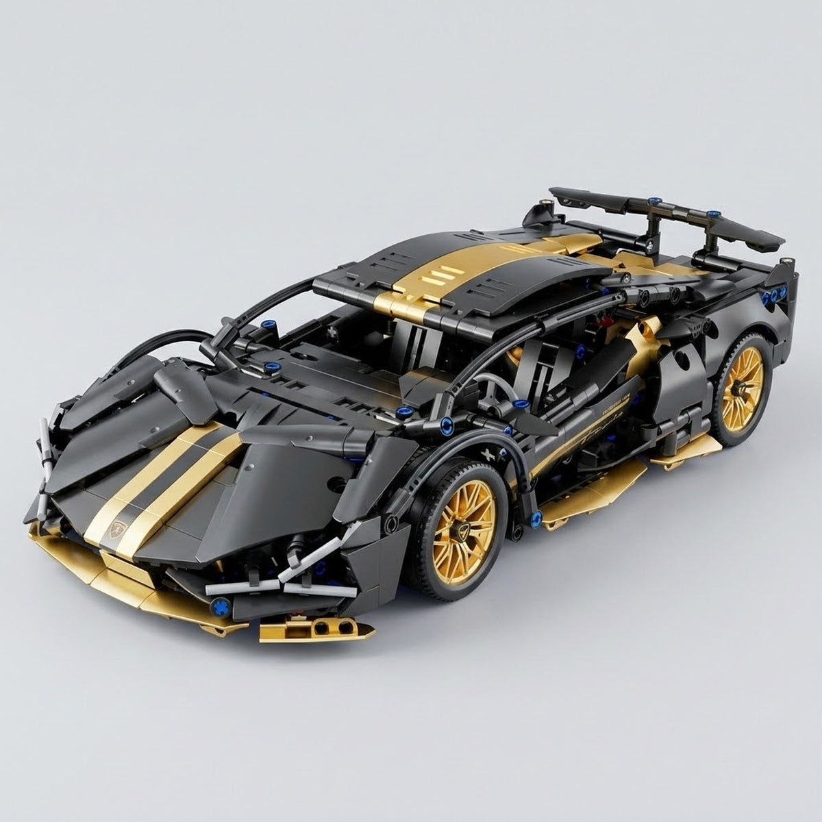 An assembled black and gold car building kit appears from a front three-quarter angle, with gold wheels and a spoiler against a gray background.
