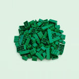 Dark green plastic building blocks in assorted rectangular sizes form a compact pile on a pale mint background.