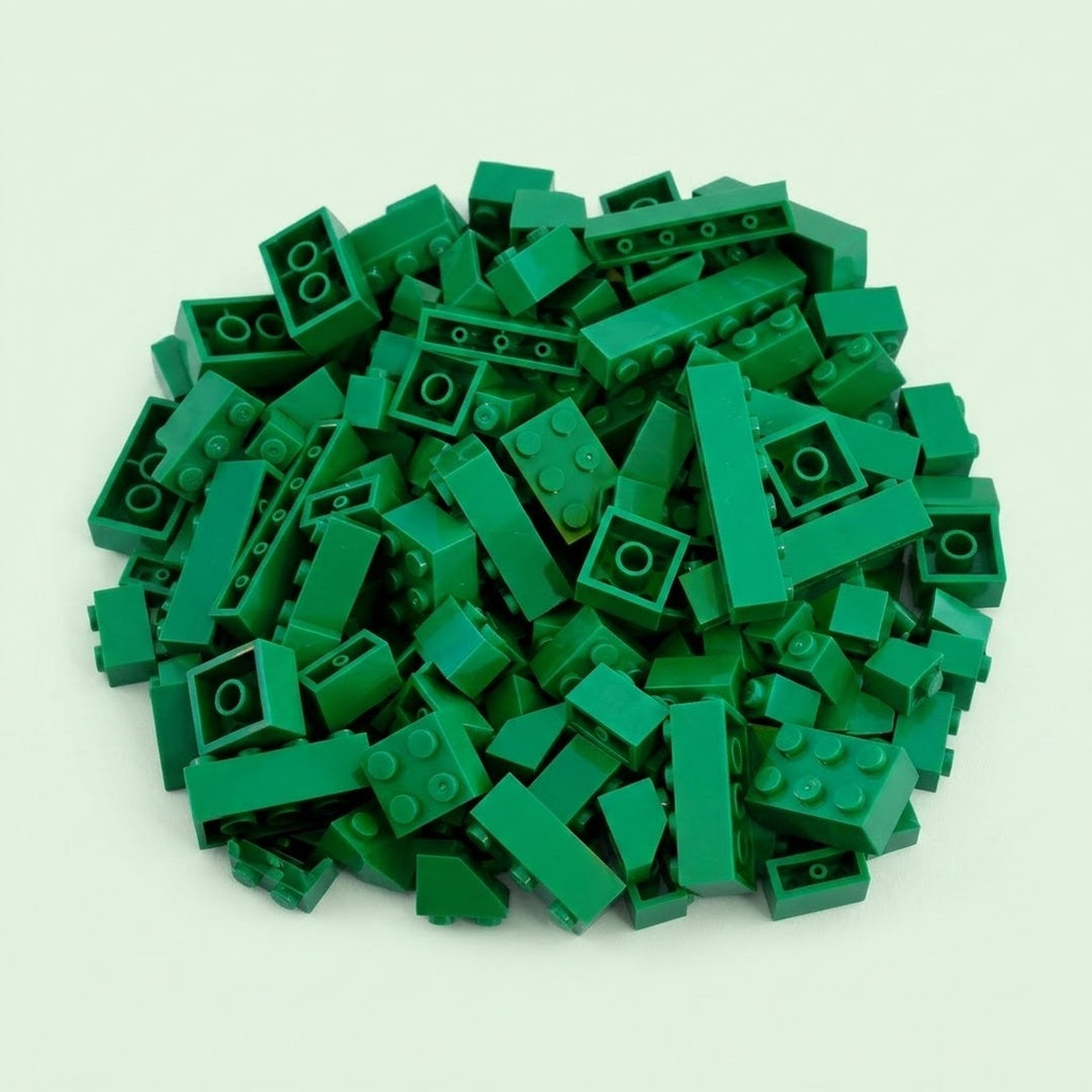 Dark green plastic building blocks form a broad pile with raised studs and hollow undersides visible against a pale mint background.