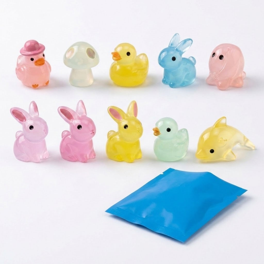 Ten translucent pastel resin miniature figurines shaped like animals and a mushroom stand behind a blue blind bag on a white background.