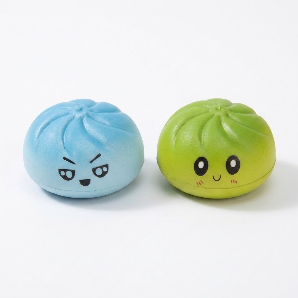 Blue and lime green steamed-bun squishy toys with cartoon expressions sit side by side against a white background.