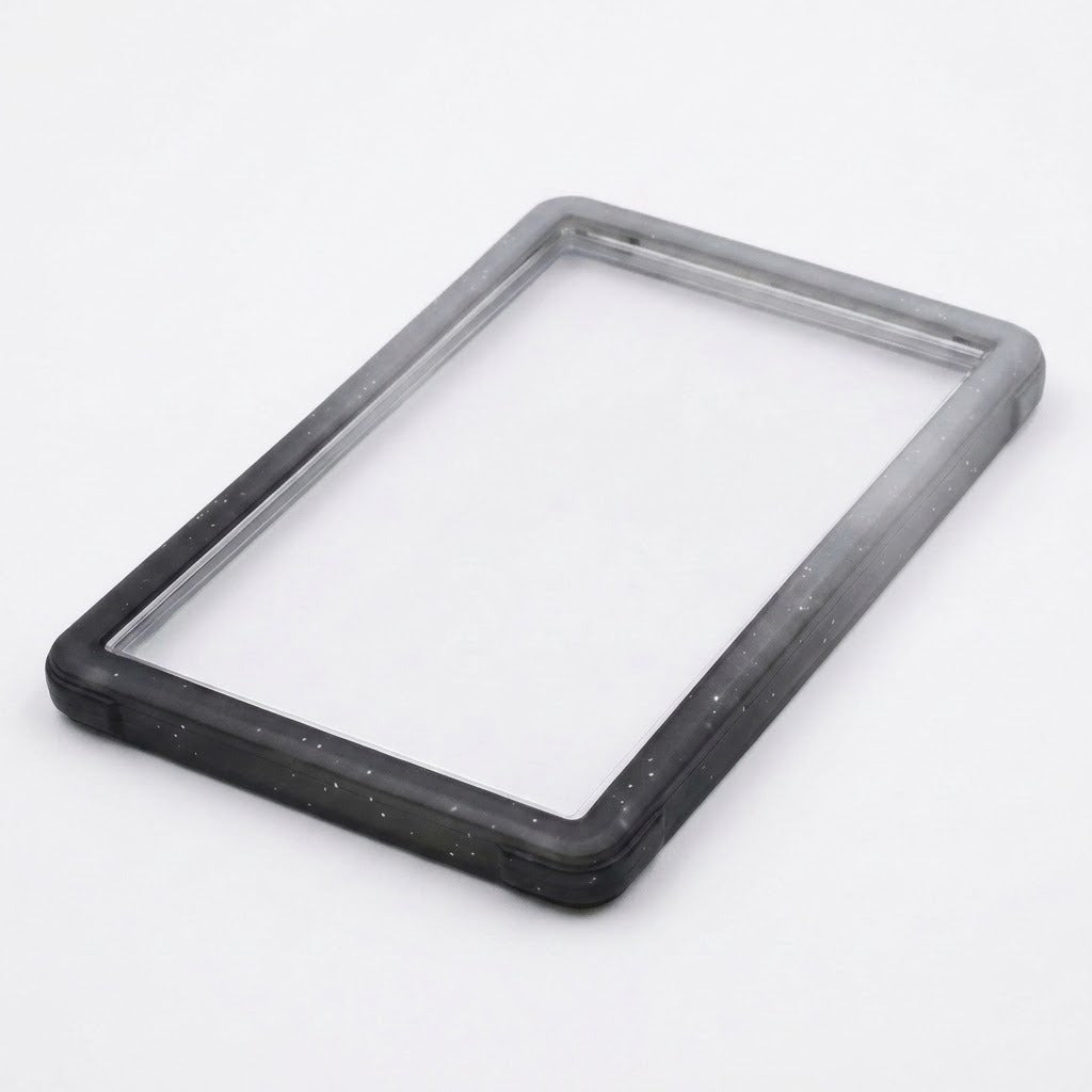 Black-gray slab bumper lies diagonally on a white background, showing its empty rectangular center and speckled edges.