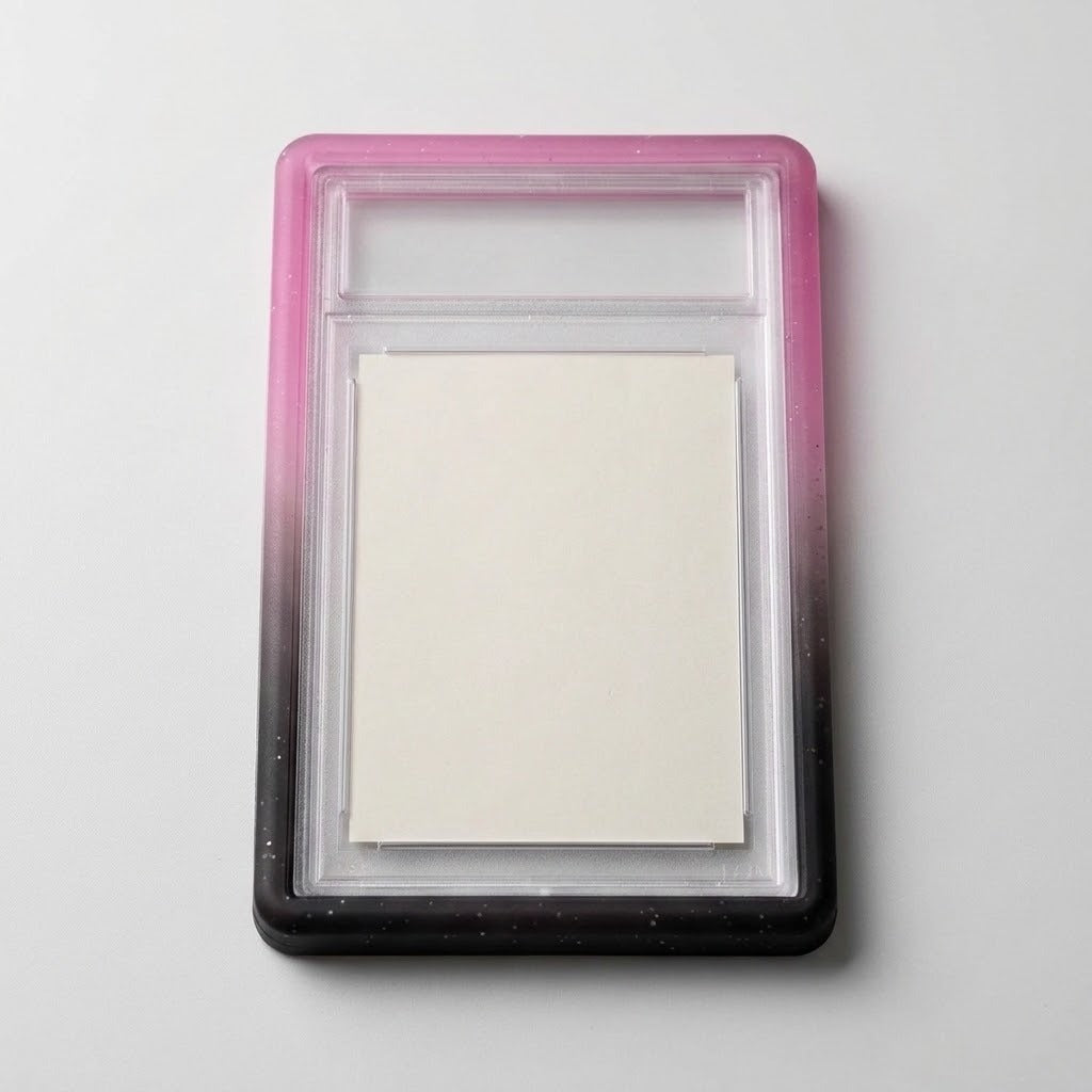Pink-black slab bumper surrounds a clear slab containing a blank cream card on a light gray background.