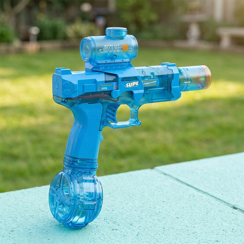 A translucent blue electric water gun with cylindrical top tank and round base stands on a pale blue surface outdoors.