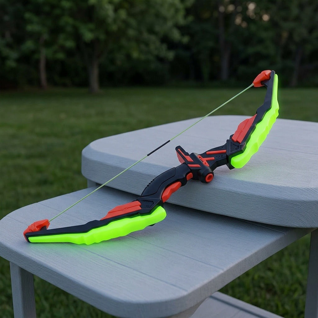 A toy archery set bow with bright green limbs and black and red details rests on gray outdoor furniture beside a lawn.