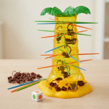 Board game with a translucent yellow plastic palm tree, brown monkeys, colorful sticks, and a die on a light wood tabletop.