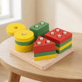 A colorful wooden shape-sorting toy set displayed on a light wood tray, placed on a round wooden table in a softly lit indoor setting.