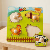 A colorful wooden farm-themed puzzle board with animal pieces and a cow piece placed in front, photographed on a light wood surface against a soft neutral background.