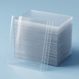 Clear card sleeves are stacked on a light blue background, with several individual sleeves leaning against the front.
