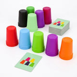 Cup stacking game with multicolored plastic cups arranged upside down beside a card deck and separate pattern card on white.