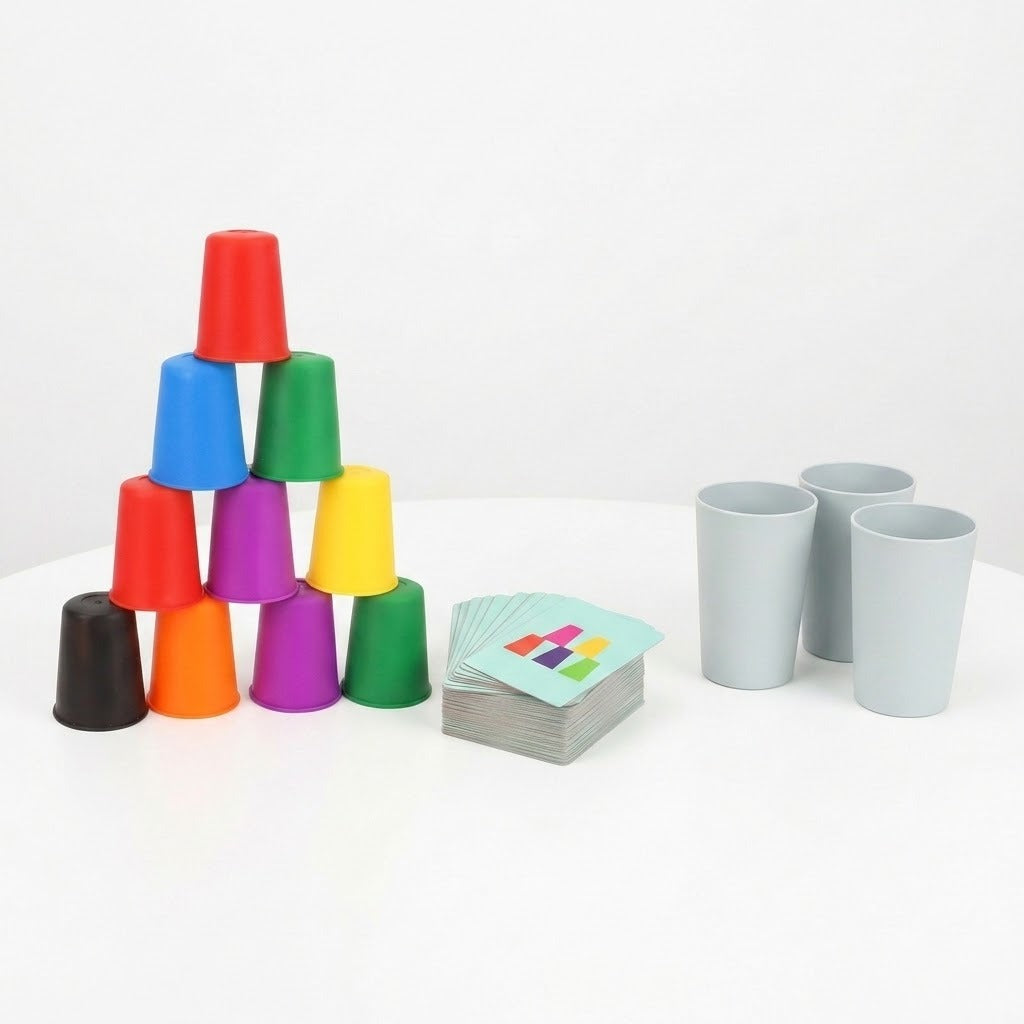 Cup stacking game with colorful plastic cups stacked in a pyramid, matching cards, and three gray cups on a white surface.