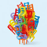 Chair stacking game with multicoloured plastic pieces featuring varied backrests, balanced in a tall, irregular tower against a pale blue background.