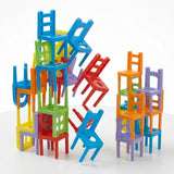 Chair stacking game with multicoloured plastic pieces forming two uneven towers, with several chairs tipping between them against a white background.