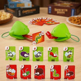 Frog tongue party game with green masks, red tongues, and numbered insect targets on a wooden table beside snacks and game boxes.