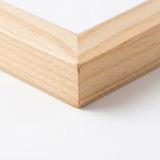 Close-up of the mitered corner of a light natural wooden shut the box dice game board against a white background.