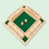 Natural wooden four-sided dice game with tiles numbered 1–10, two wooden dice, and a green felt center on a pale mint background.