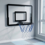Black mini basketball hoop with a blue and white net mounted beside a window above interlocking foam floor mats.