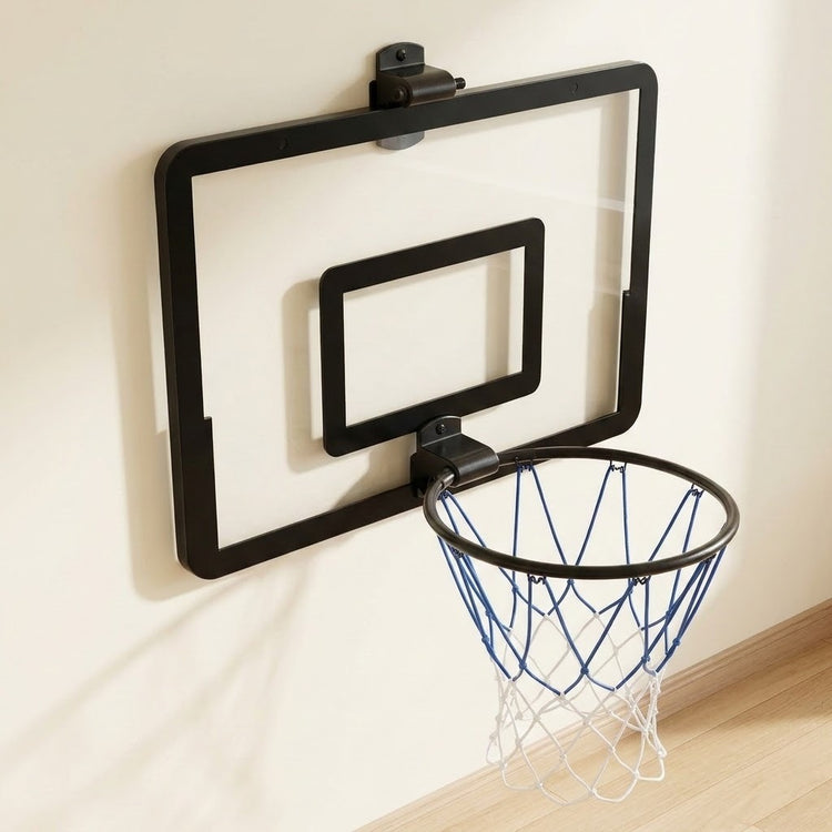 Black mini basketball hoop with a clear backboard and blue and white net mounted on a cream wall above wooden flooring.