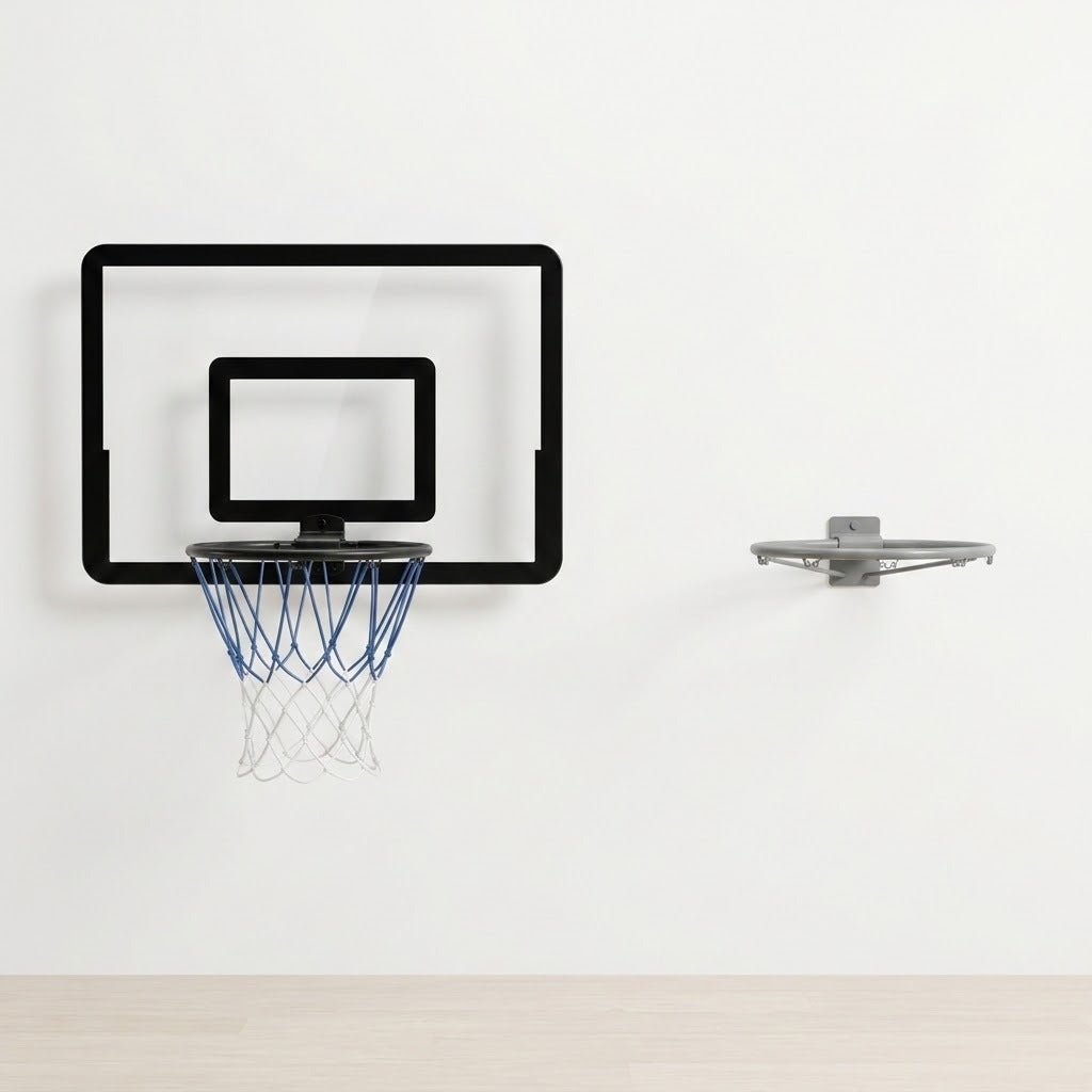 Black-bordered basketball hoop with a clear backboard and blue and white net hangs on a white wall beside a separate grey rim.