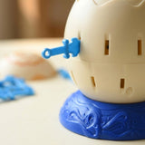 Tabletop game close-up shows a blue sword inserted into a cream barrel on a textured blue base, with loose pieces blurred behind.