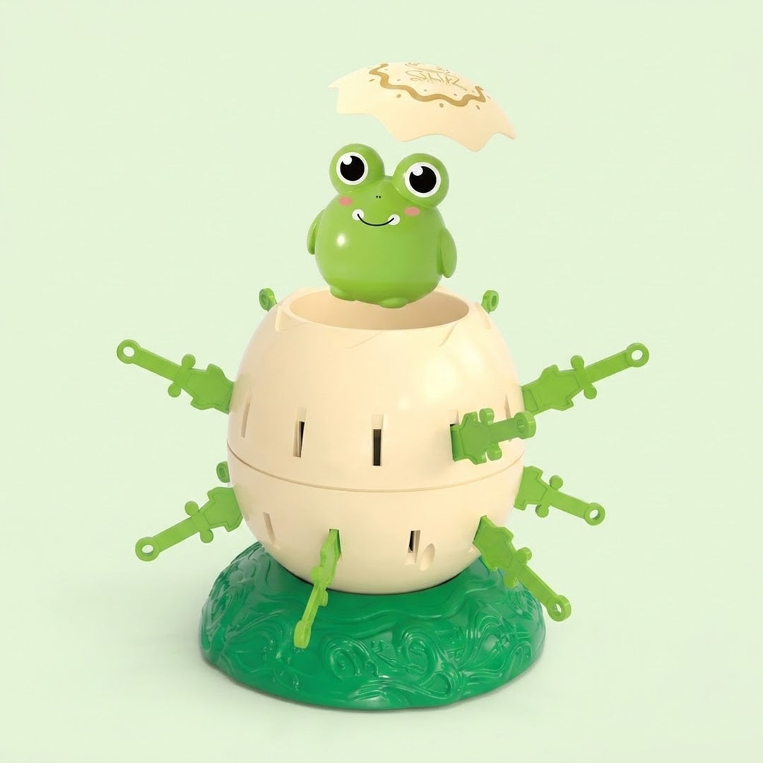 Tabletop game with green frog, raised cream lid, cream shell, green swords, and green base against a pale green background.