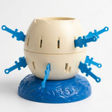 Tabletop game with a cream egg-shaped barrel and inserted blue swords rests on a textured blue base against a white background.
