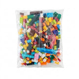 Multicolored plastic building blocks in assorted shapes fill a clear sealed bag against a plain white background.