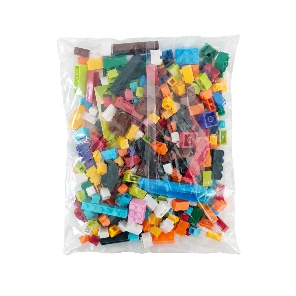 Multicolored plastic building blocks in assorted shapes fill a clear sealed bag against a plain white background.