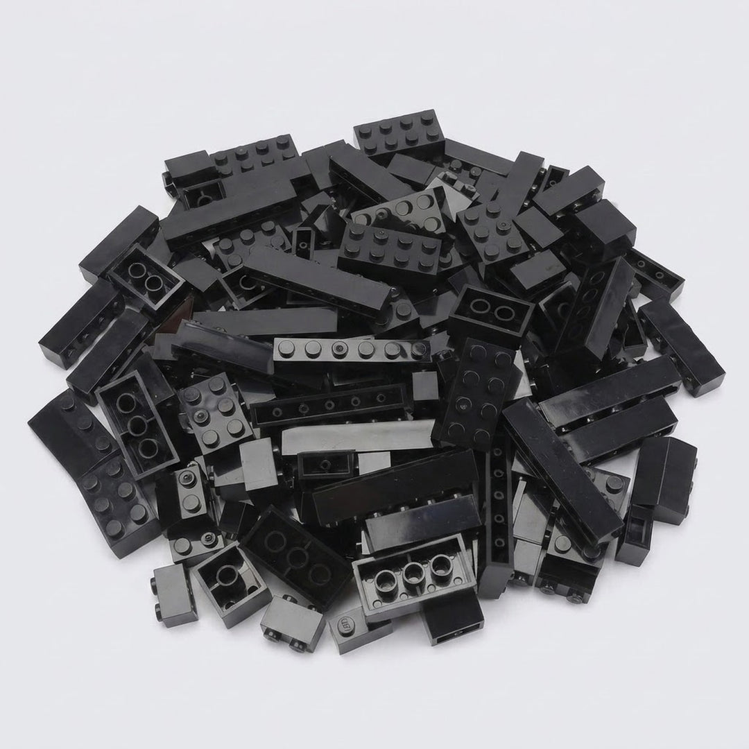 A large pile of assorted black plastic building bricks in various shapes and sizes on a plain white background, from a set of 240 pieces.