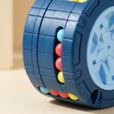 Close-up of a blue fidget puzzle showing segmented grooves, colorful beads and part of its pale blue wheel end.