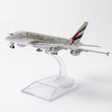 White model airplane with landing wheels extended on a curved clear stand against a white background.