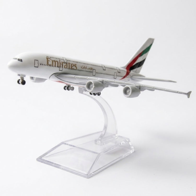 White model airplane with landing wheels extended on a curved clear stand against a white background.