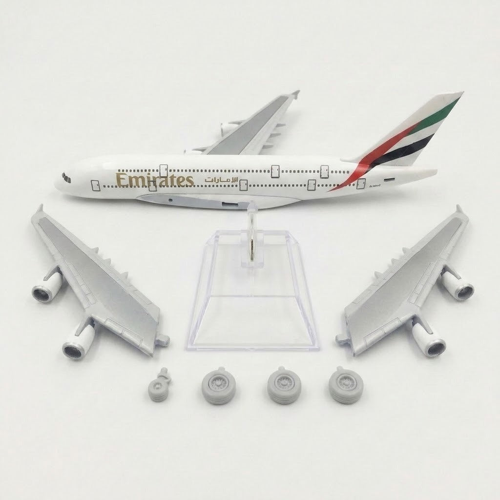 White model airplane fuselage, detached silver wings with engines, four landing gear pieces, and clear display stand arranged on white.