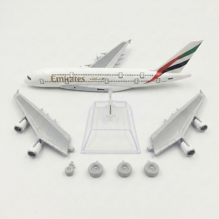 White model airplane fuselage, detached silver wings with engines, four landing gear pieces, and clear display stand arranged on white.