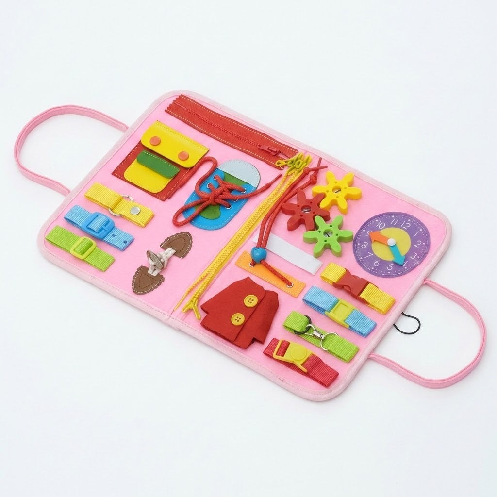 An open pink felt busy board with buckles, zippers, shoelaces, colorful gears and a purple numbered clock lies on white.