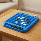 Blue plastic reversi game with black and white discs and edge storage slots on a wooden coffee table beside a beige sofa.