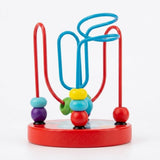Bead maze learning toy with colorful wooden beads and looping turquoise and red wires on a round red base against white.