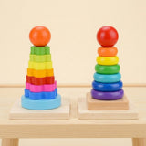 Wooden rainbow flower and ring stacking learning toys stand on raised wooden platforms against a cream background.