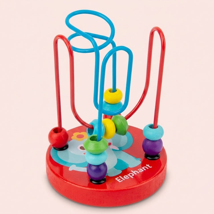 A wooden bead maze learning toy has colorful beads, red and blue tracks, and a red elephant-decorated base against a pale pink background.