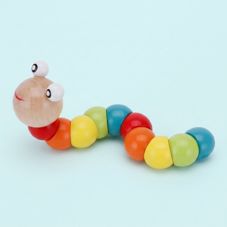A wooden caterpillar learning toy with rainbow segments, raised white eyes, and a red smile curves across a pale blue background.