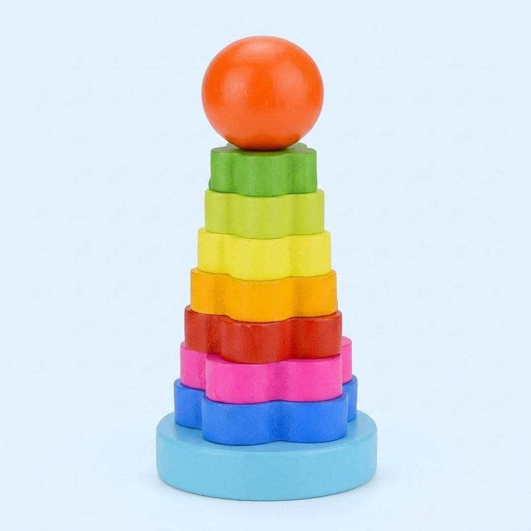 A wooden flower stacking learning toy has rainbow pieces, an orange ball top, and a light blue base against a pale blue background.