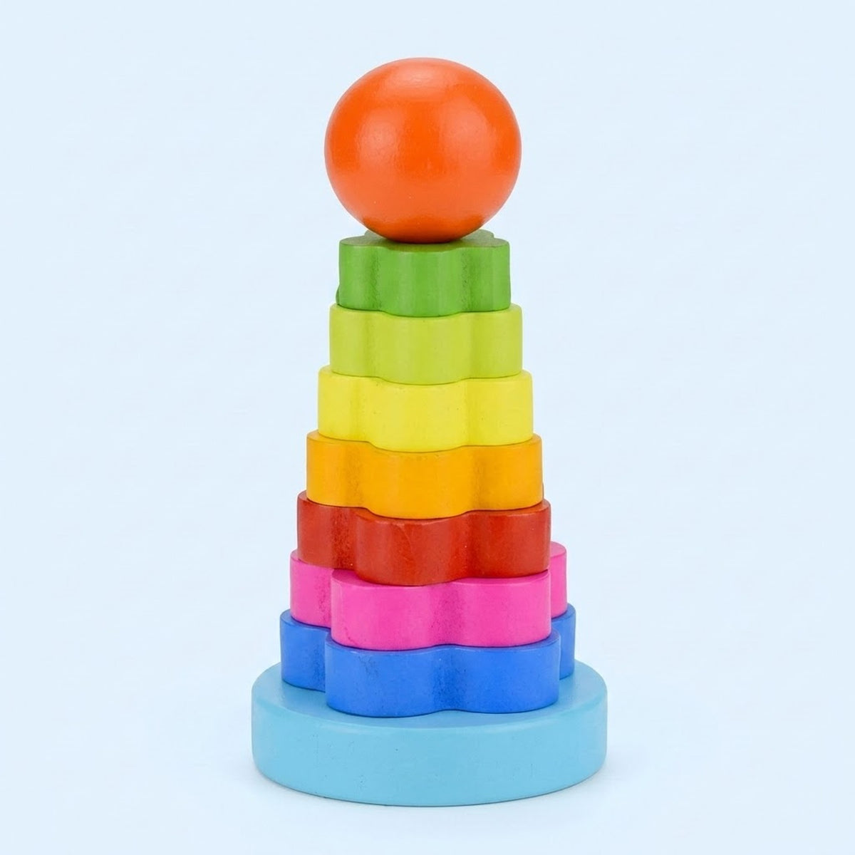 A wooden flower stacking learning toy has rainbow pieces, an orange ball top, and a light blue base against a pale blue background.